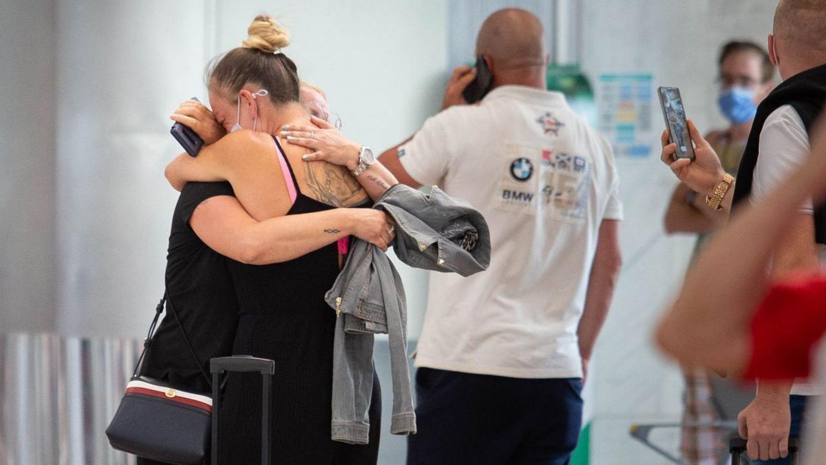 Dos mujeres se abrazan en la terminal del aeropuerto de Tenerife Sur. | | CARSTEN LAURITSEN