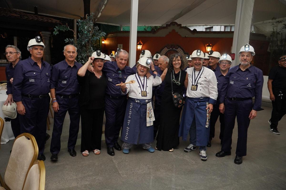 La guisandera Mary Fernández y el presidente de la Cofradía del Desarme, Miguel Ángel de Dios, con integrantes del Coro Minero de Turón en el festival "Señardá".