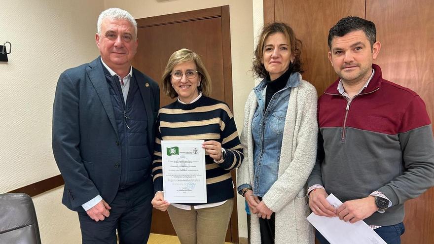 La alcaldesa muestra el documento que acredita el reconocimiento como municipio industrial.