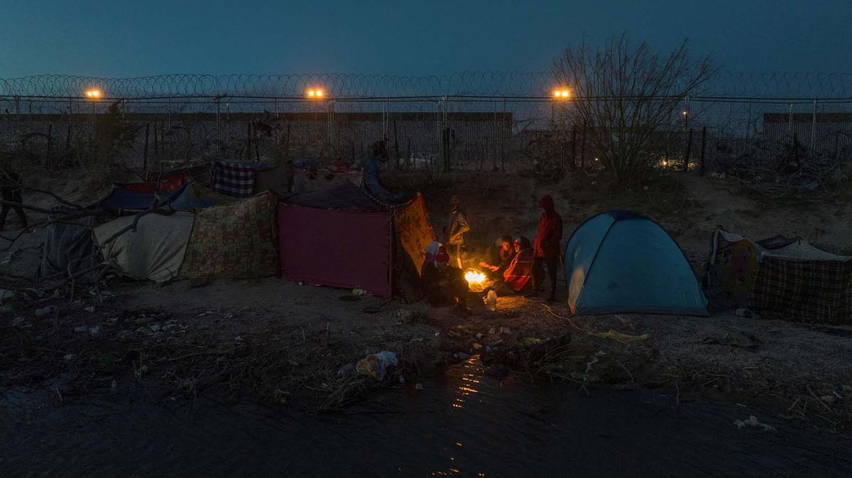 Migrantes acampan a lo largo de la orilla del río Grande mientras esperan entregarse a las autoridades de inmigración en El Paso, Texas, EE.UU