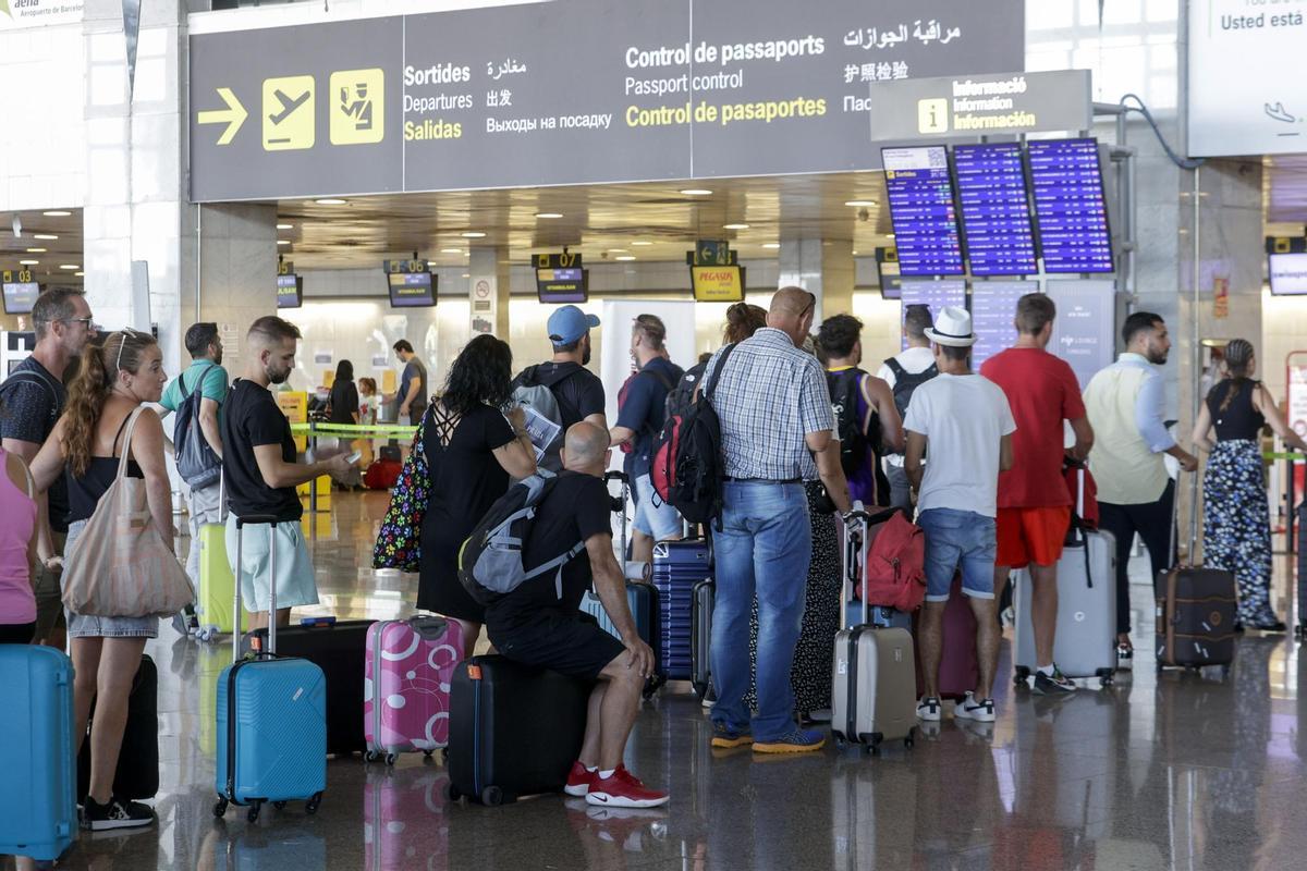 Varios pasajeros hacen cola ante uno de los mostradores de facturación en la Terminal 2 del Aeropuerto de Barcelona-El Prat.  EFE/ Quique García/Archivo