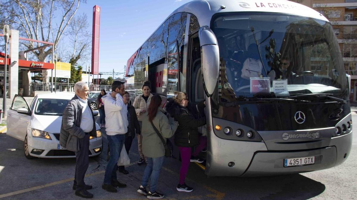 Usuarios y usuarias del servicio por carretera entre Xàtiva y Alcoi suben a un autobús en la estación de ferrocarril setabense