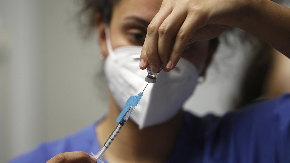 Una enfermera prepara la vacuna Pfizer-BioNtech contra el COVID-19 antes de administrársela a un profesional sanitario.