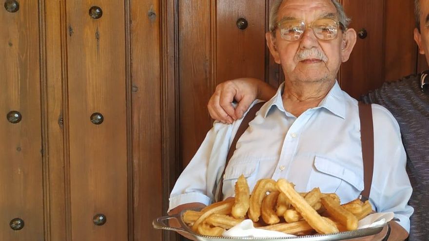 Ángel López Rivas junto a su hijo sosteniendo una bandeja de churros