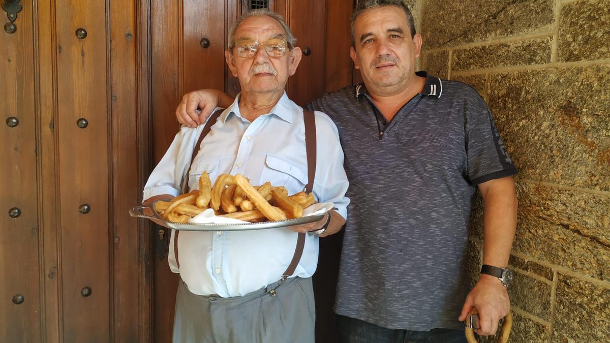 Ángel López Rivas junto a su hijo sosteniendo una bandeja de churros