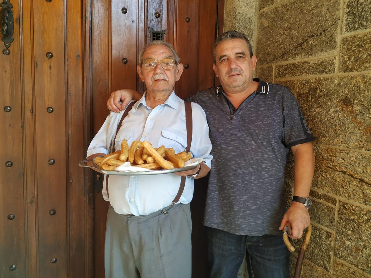 Ángel López Rivas junto a su hijo sosteniendo una bandeja de churros