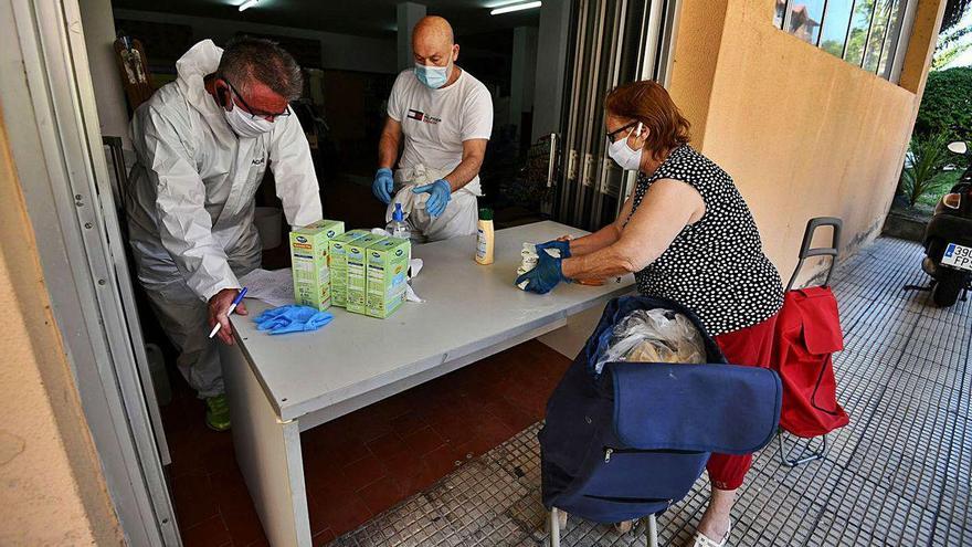 Trabajadores de una ONG entregan alimentos a una mujer durante el estado de alarma.