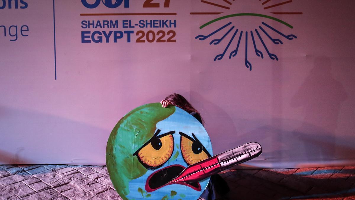 Una activista sostiene un cartel durante la cumbre del clima, este sábado, en Sharm el Sheikh.