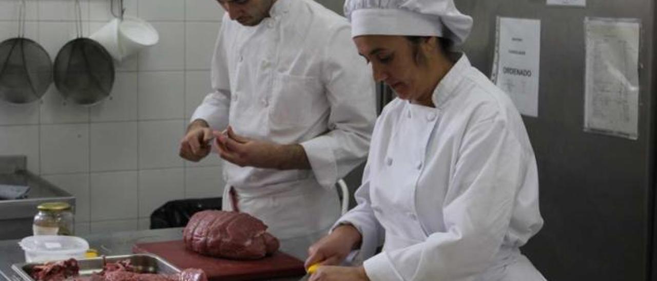 Rebeca Fraga y Carlos Martínez manejando la carne.