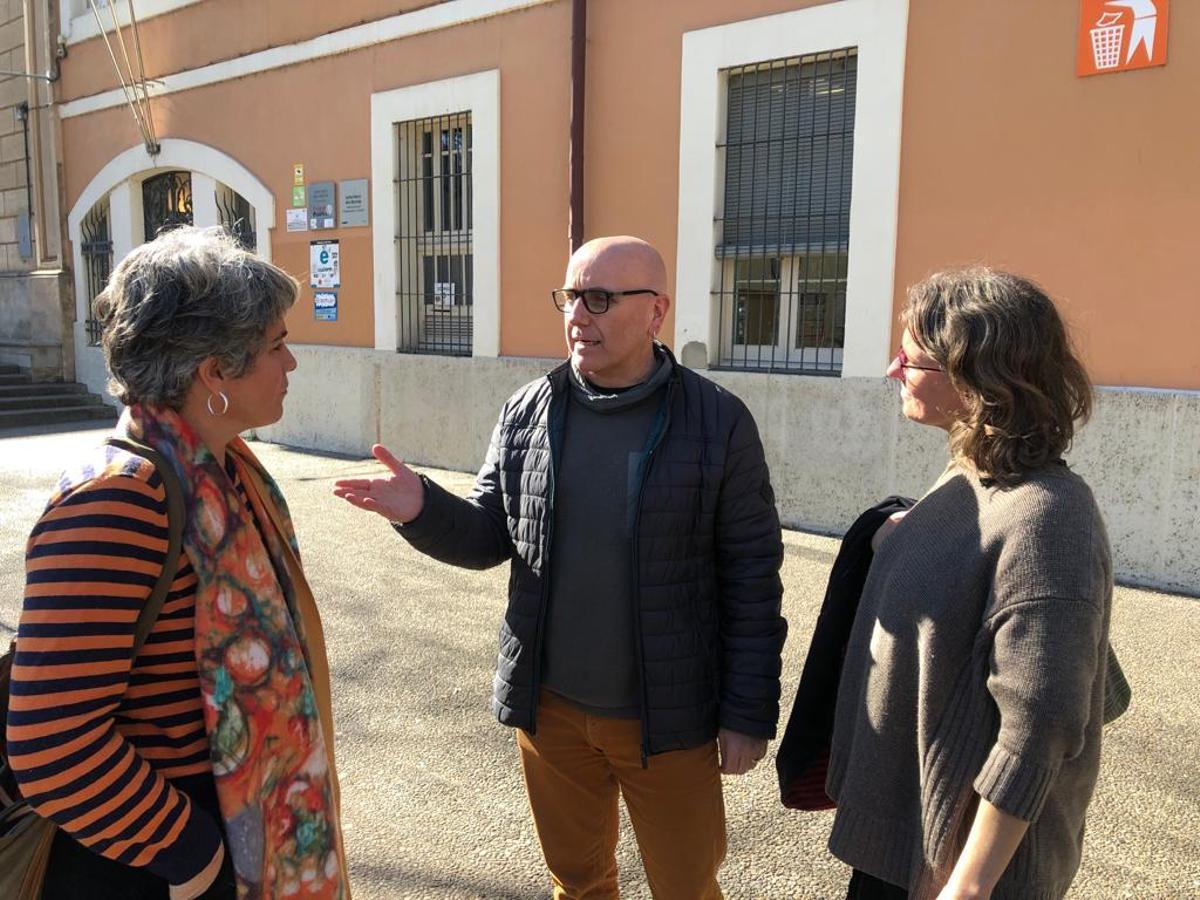 La regidora de Guanyem Cristina Andreu, el president de l'AMPA de l'institut Narcís Xifra, Roger Casero, i la candidata de Guanyem Girona Queralt Vila, en una visita a l'institut avui.