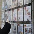 Una joven mira los precios de la vivienda en una inmobiliaria.
