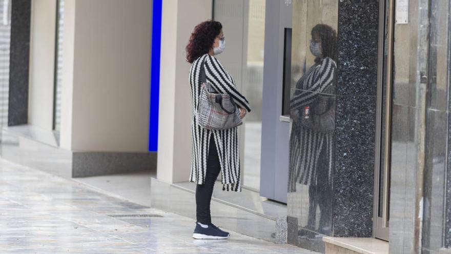 Una mujer mira su propio reflejo en un escaparate de Cartagena.