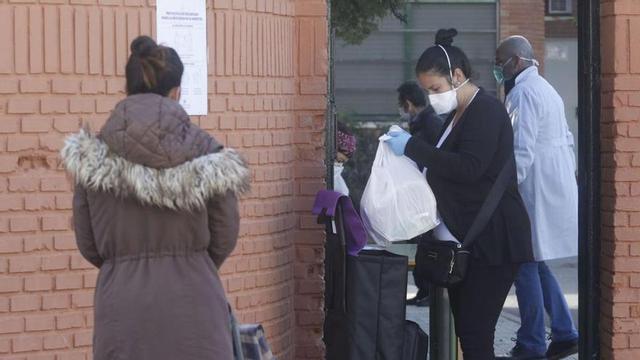 Mujeres recogen comida para niños en riesgo de exclusión en un colegio cordobés durante la pandemia.