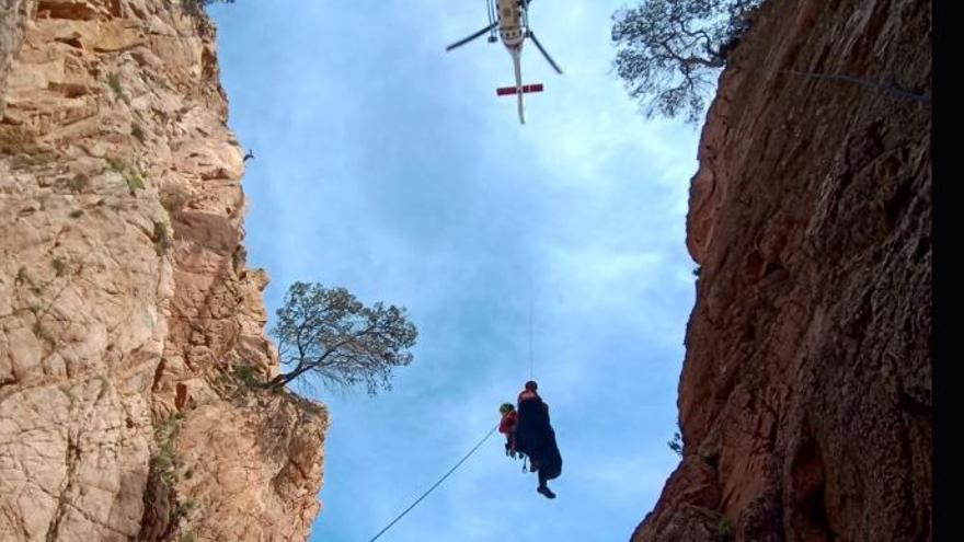 L'helicòpter dels Bombers rescatant una persona a la via ferrada de Sant Feliu de Guíxols.