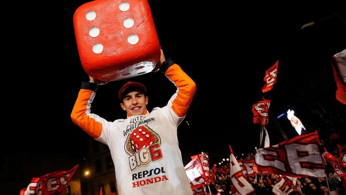 Márquez sostiene en Cervera un gran dado con los seis títulos que ha ganado.