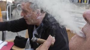 Un fumador treu el fum d’un cigarro a la terrassa d’un bar. | FERRAN NADEU