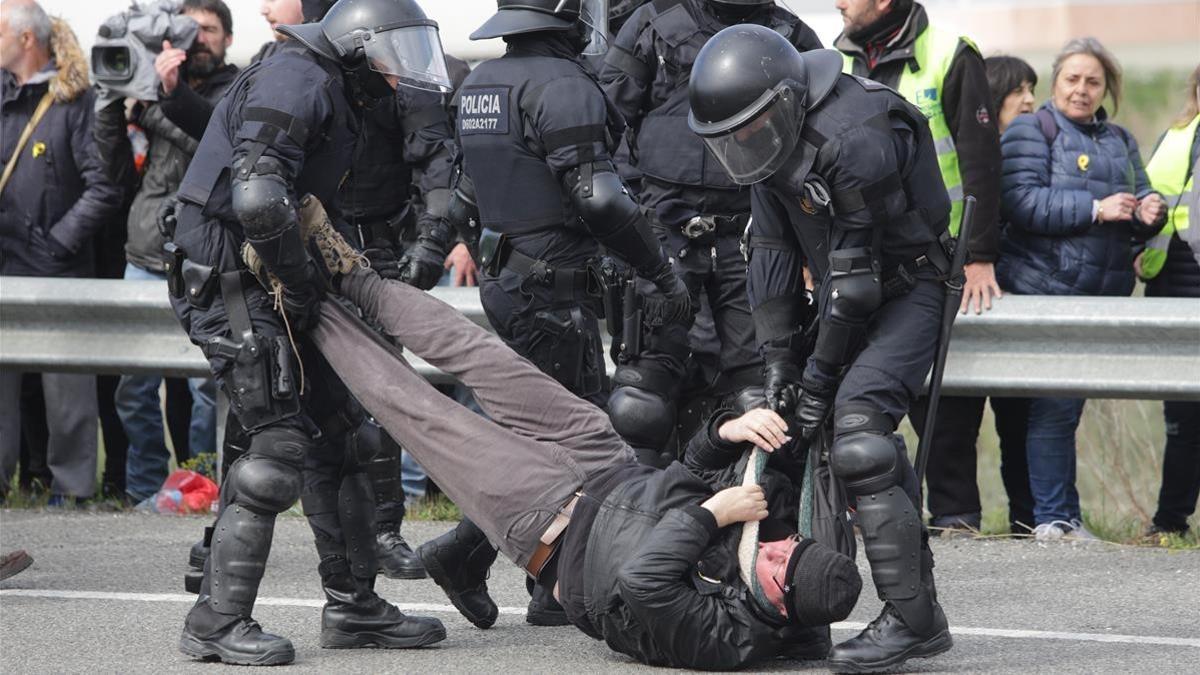 Agentes de la Brimo de los Mossos desalojan por la fuerza a los manifestantes de la AP-7, a la altura de Figueres.