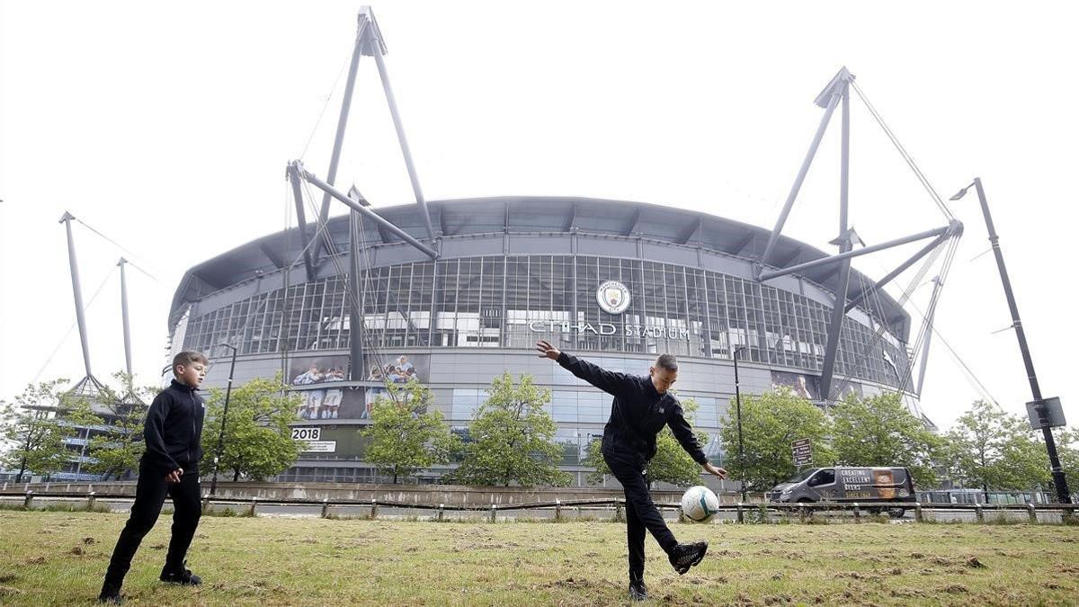 Dos chicos juegan en los aledaños del Etihad Stadium, la sede del Manchester City,