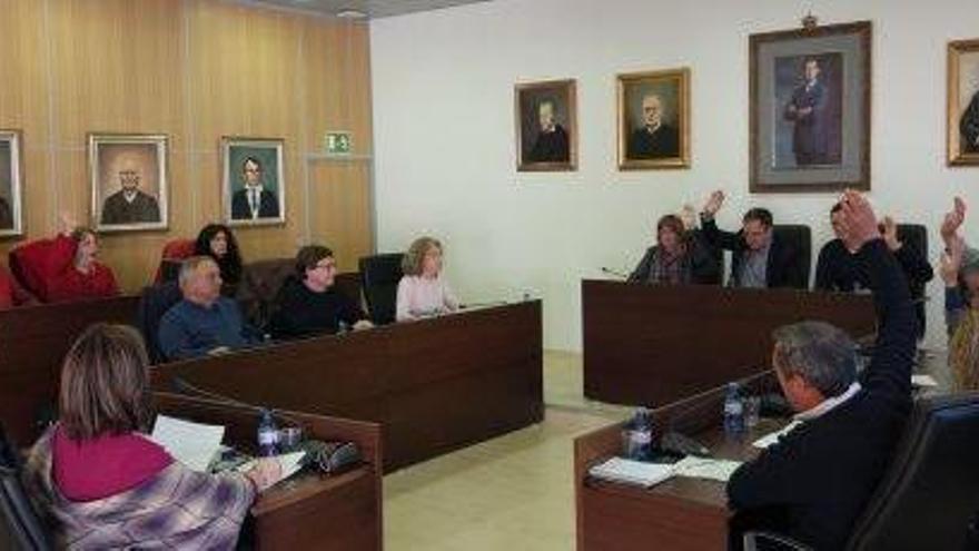 El equipo de gobierno, a la derecha, levanta el brazo durante la votación de un punto del orden del día.