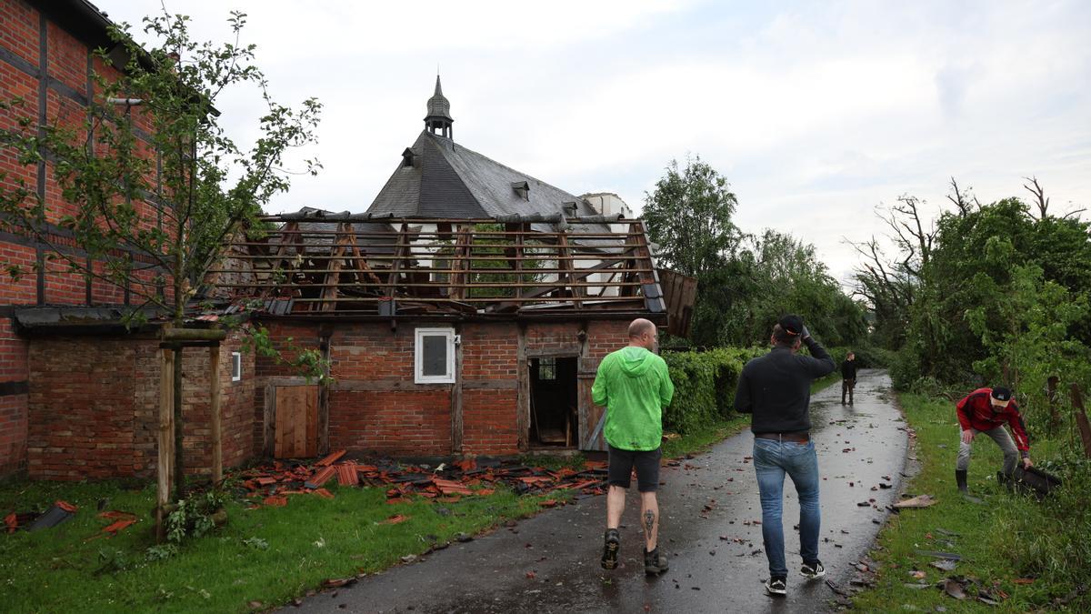 Ciudadanos frente a una casa afectada después de que un tornado causara daños masivos en Lippstadt.