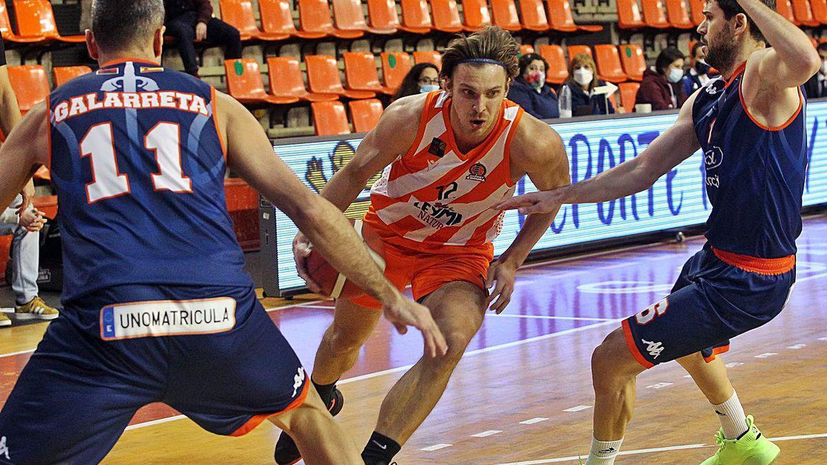 Peciukevicius, entre dos jugadores del Burgos, en el partido de ayer del Leyma.