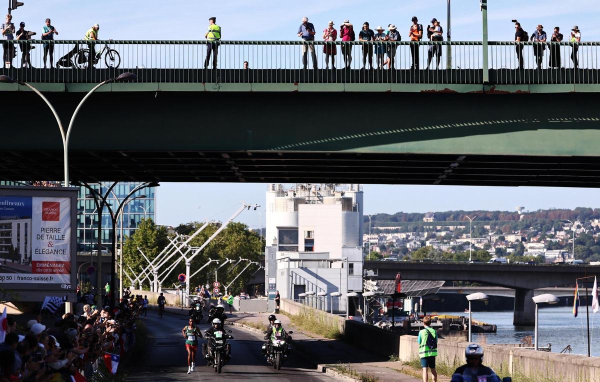 La gente observa desde un puente a Tamirat Tola de Etiopía durante la maratón en loa Juegos Olímpicos de Paris 2024