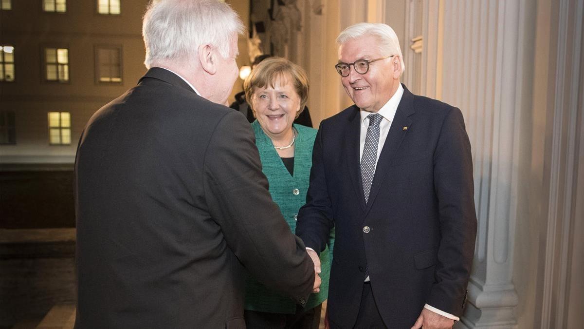 El presidente alemán, Frank-Walter Steinmeier (derecha) saluda al primer ministro bávaro y presidente de la CSU, Horst Seehofer (izq), junto a la cancillera Merkel, en Berlín, el 30 de noviembre.