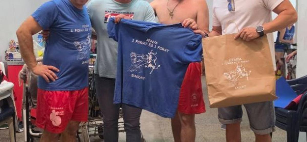 Camisetas y una bolsa con el logo de la peña.