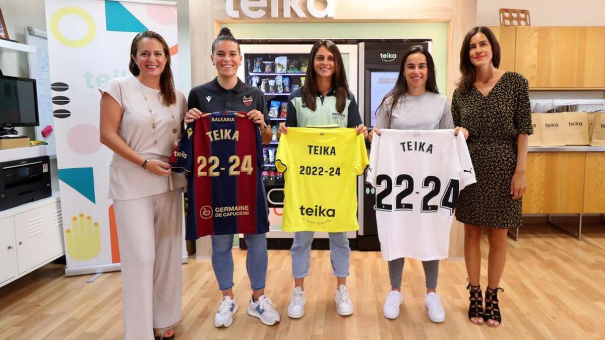 jugadoras y representantes de Teika posan con las camisetas. | F.CALABUIG