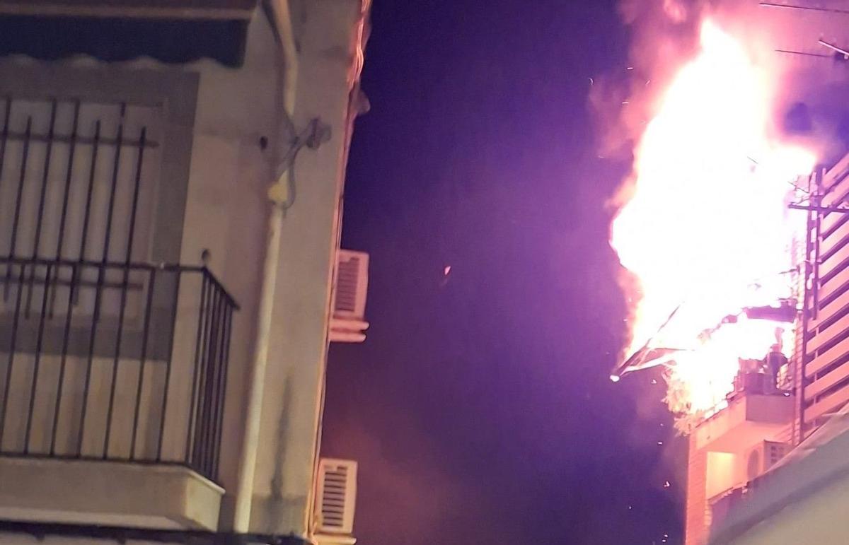 Las llamas salen por el balcón de la vivienda que ha sufrido un incendio la pasada madrugada en Cabra.