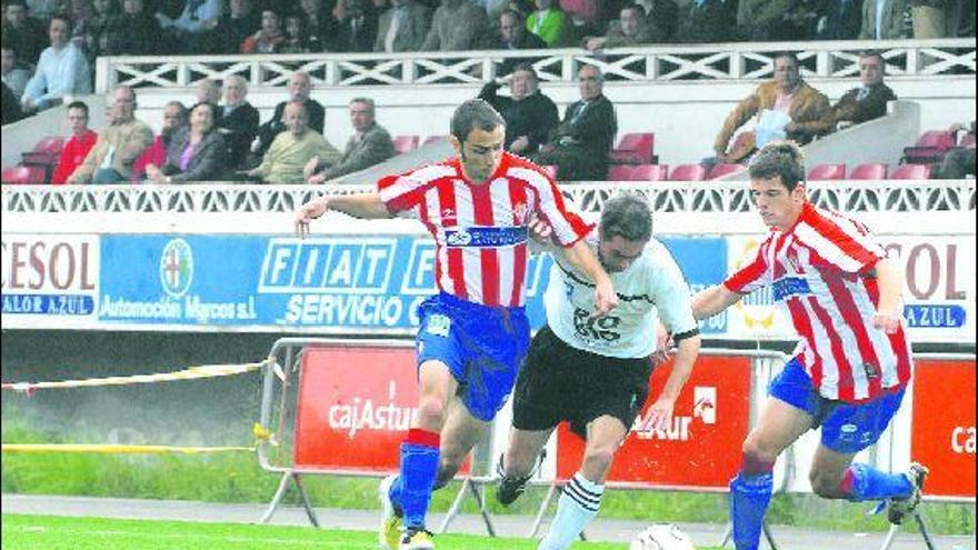 El extremo zurdo caudalista Dubo trata de irse entre dos jugadores del Sporting B.