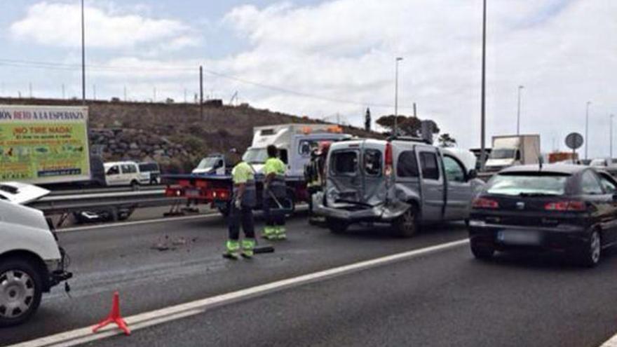 Operarios, junto a un vehículo implicado en el primer choque, ayer. | policía local