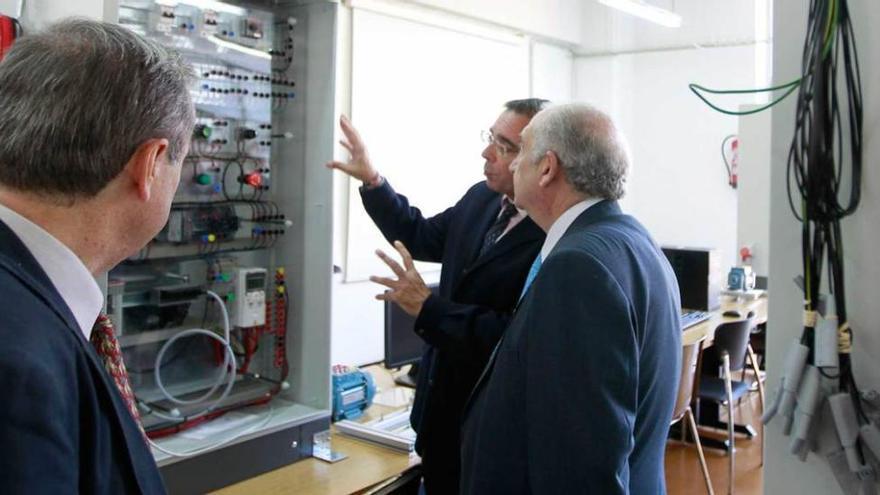 Un directivo de ABB le explica al rector, Vicente Gotor, el funcionamiento de uno de los ocho equipos de automatización y control instalados en la Escuela de Minas, Energía y Materiales, en Oviedo.