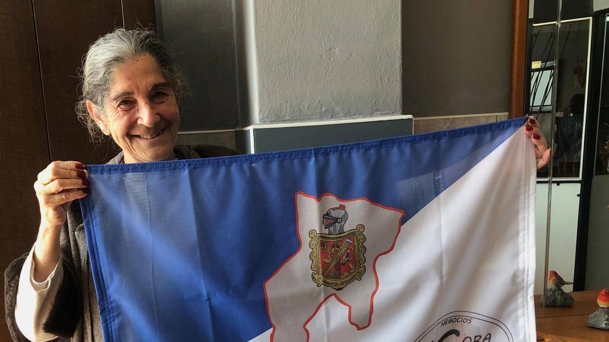 Sagra Fernández, con la bandera de Grado y el logo del colectivo