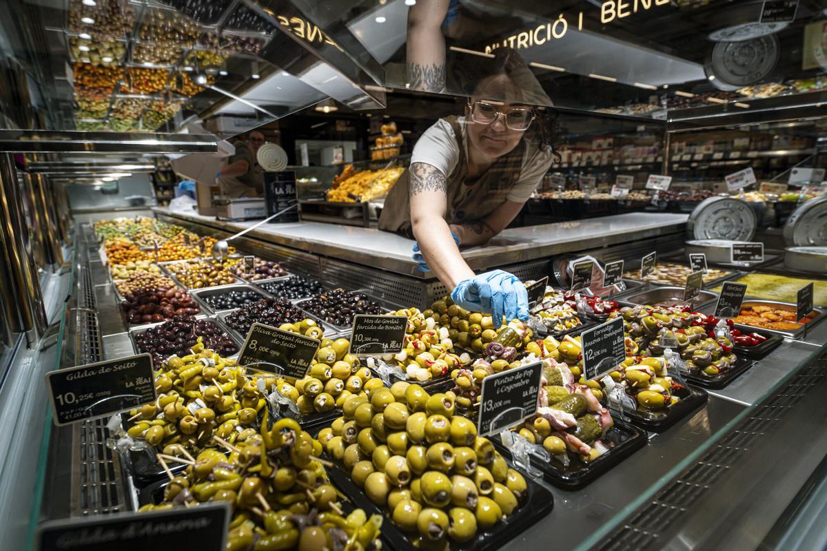 Una dependienta atiende en un supermercado de El Corte Inglés en Barcelona, este año