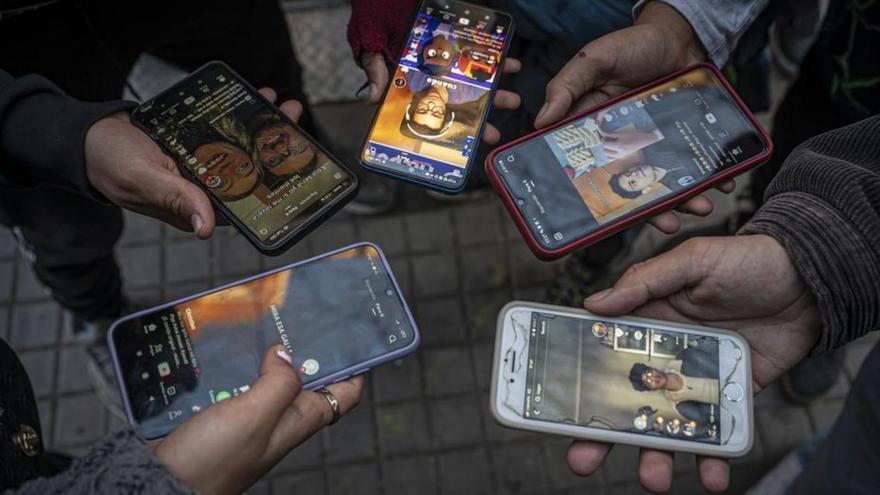 Un grupo de jóvenes usando TikTok en la calle. | Manu Mitru