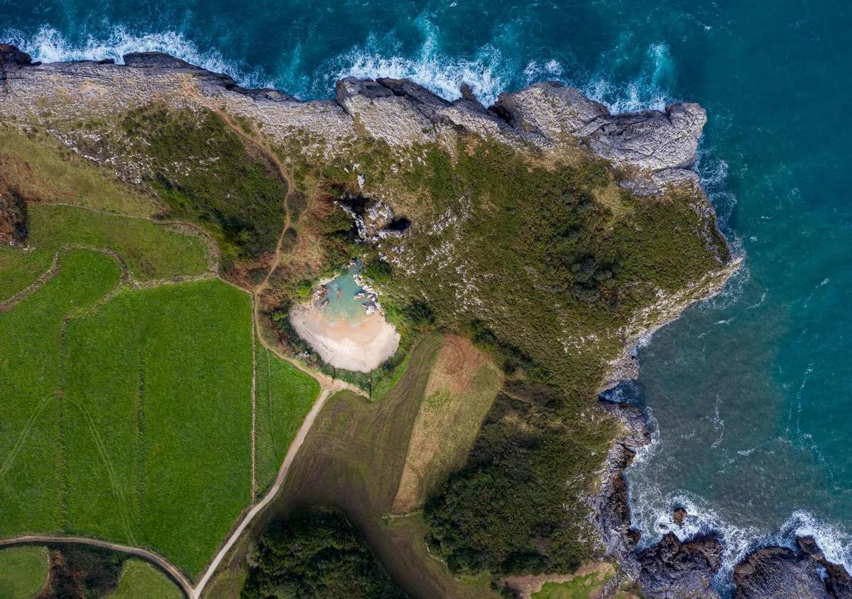 La Playa de Gulpiyuri en Llanes, Asturias, es un destino veraniego que combina la belleza natural con la singularidad geológica.