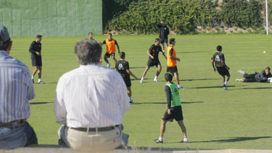 Dos aficionados siguen el entrenamiento que ayer realizó el Cartagena en las instalaciones de La Manga Clu