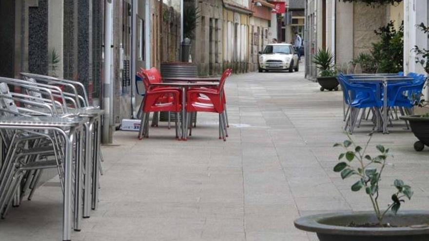 Imagen en la que se aprecian diferentes tipos de mobiliario, terrazas y/o colores      en una misma calle de O Grove.  //  Muñiz