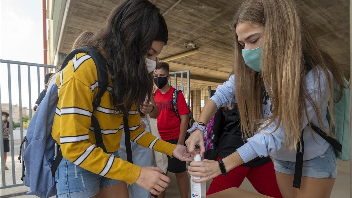 Dos alumnas se aplican desinfectante en el Institut Despuig de Tortosa.