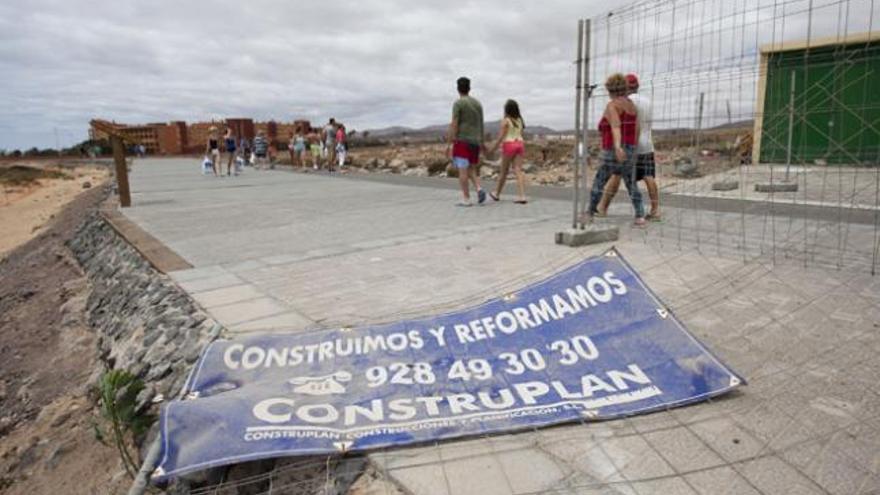 Los turistas en el paseo marítimo entre las vallas y material en el suelo. | gabriel fuselli