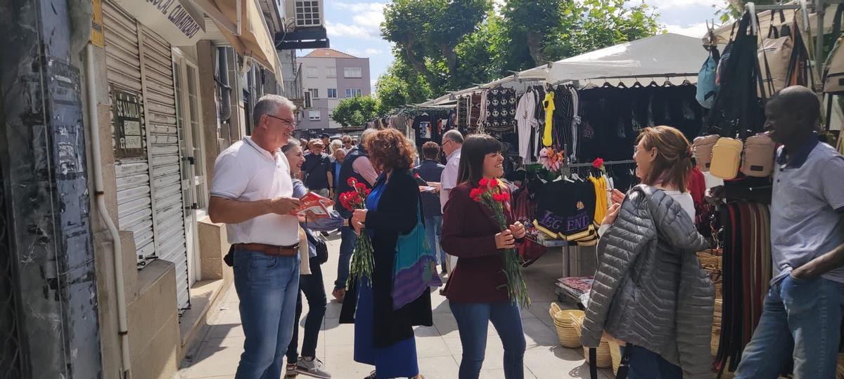 La candidata del PSOE de Cangas, Iria Malvido, repartiendo flores en el mercado.jpg