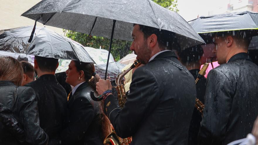 Músicos de la Hermandad del Cautivo de San Pablo de Sevilla se marchan tras suspenderse por la lluvia su estación de penitencia. (Foto de archivo).