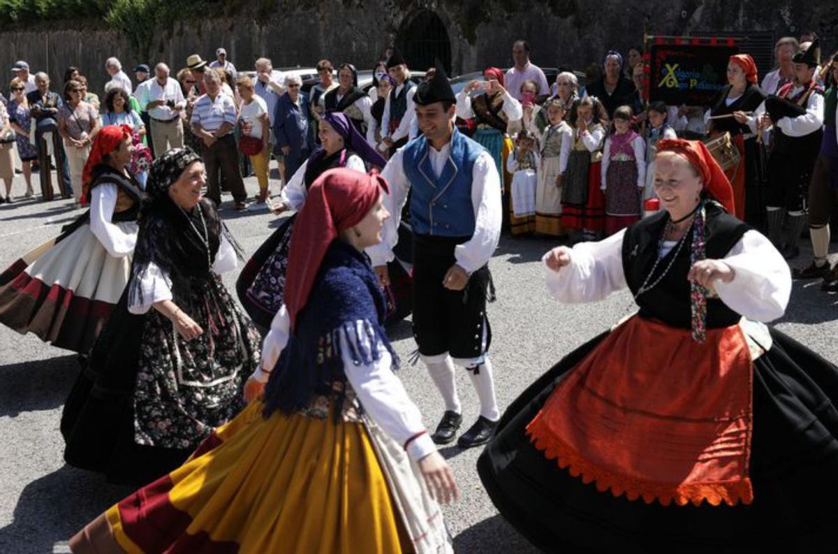 Por la izquierda, Sanz Montes, durante la misa;  el grupo folclórico «Xolgoriu», y feligreses a la puerta del santuario, con el «ramu». | J. P.