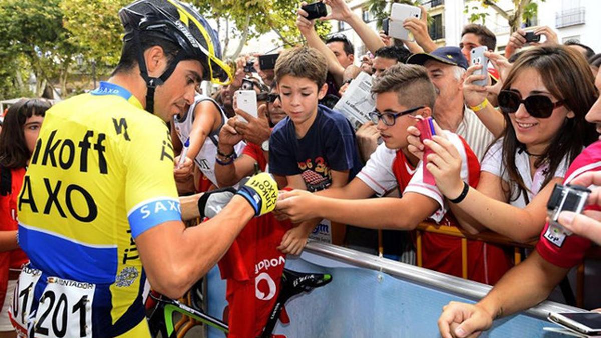 Contador firmando autógrafos a la salida de la etapa