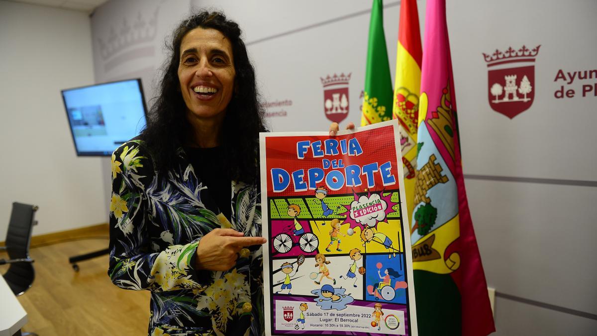 La concejala, con el cartel de la feria del deporte de Plasencia.