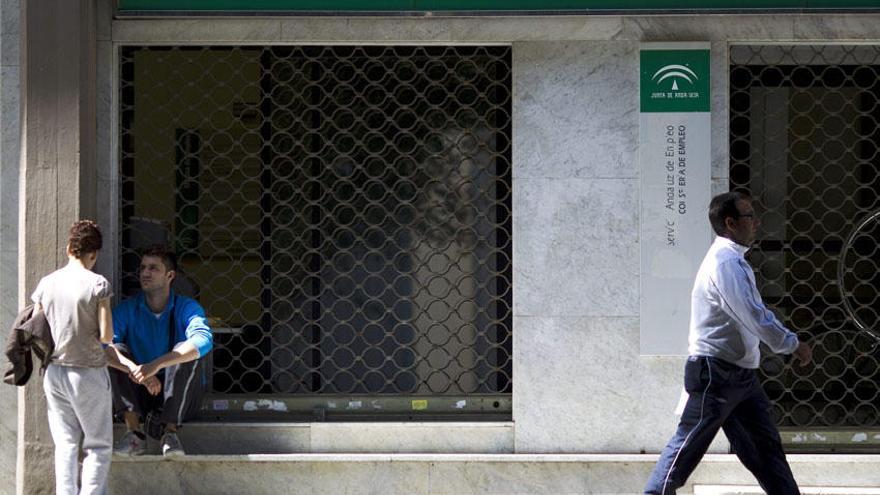 Unas personas en la puerta de una oficina de empleo de la Junta de Andalucía en Málaga.