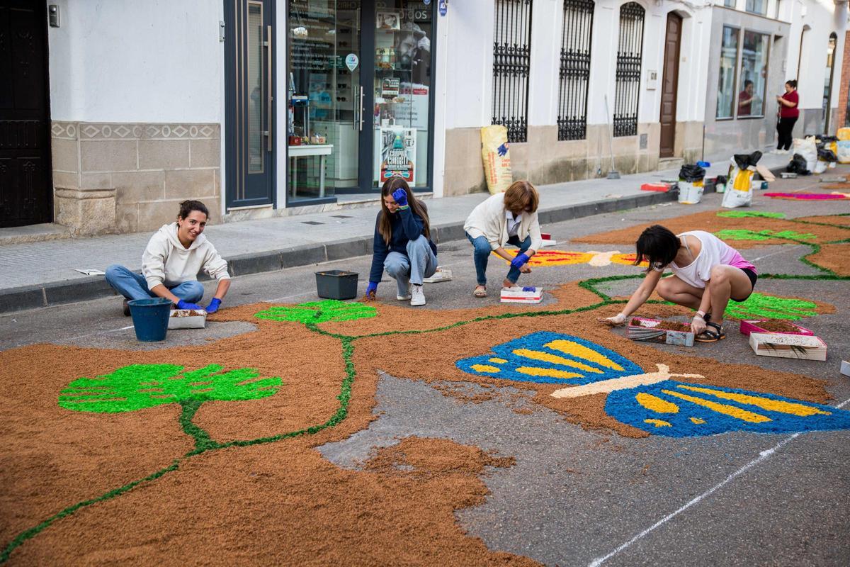 Jóvenes y niños participan en la decoración de las calles de San Vicente de Alcántara durante el Corpus Christi.