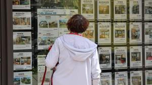 Una mujer observa los anuncios de ventas y alquileres en una inmobiliaria de Vigo.