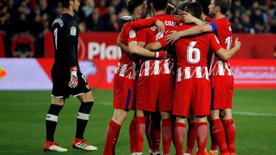 Los atléticos celebran un gol ante Sergio Rico, portero del Sevilla.